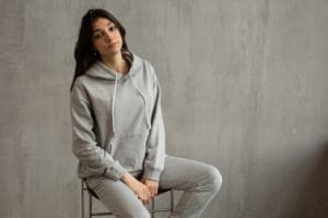 woman sitting on stool in sweatpants and hoody