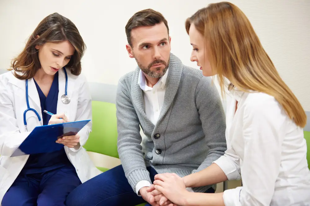 Doctor reviewing notes with concerned couple in clinic